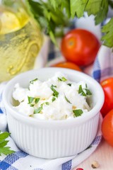 White soft cheese, feta, goat in bowl with tomatoes, parsley