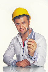 Portrait of handsome worker posing in studio with helmet and key