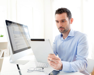 Fototapeta premium Young business man working at home on his tablet