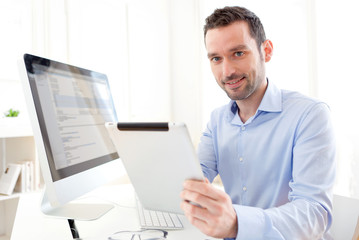 Young business man working at home on his tablet