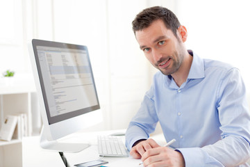 Fototapeta premium Young business man working at home on his laptop