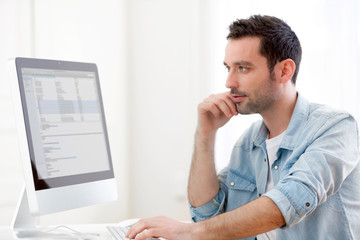 Fototapeta premium Portrait of a young relaxed man using computer