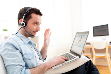 Young relaxed man video-calling on Internet