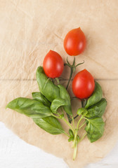bunch of  tomatoes and basil on brown paper