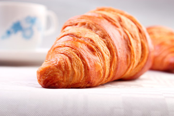 Croissant closeup on white tablecloth