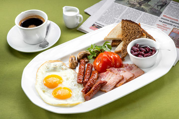 Breakfast with two eggs, bacon, beans, tomatoes, mushrooms and c