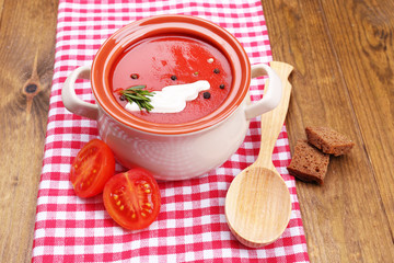 Tasty tomato soup on wooden table