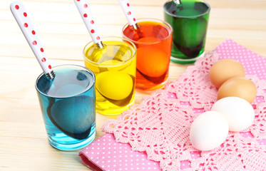 Glasses with paint for Easter eggs and eggs, close up