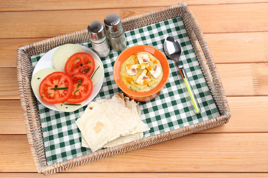 Bowl of tasty fresh hummus with tomatoes