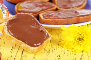 Bread with sweet chocolate hazelnut spread on plate on table
