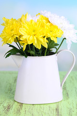 Fototapeta premium Beautiful chrysanthemum flowers in pitcher on natural