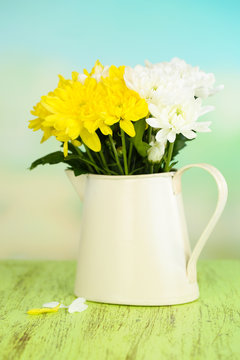 Beautiful chrysanthemum flowers in pitcher on natural