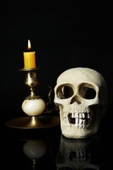 Skull and candle isolated on black