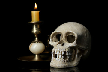 Skull and candle isolated on black