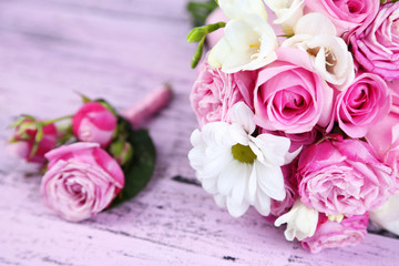 Beautiful wedding bouquet and boutonniere on wooden background