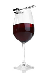 Composition with car key and glass of wine, isolated on white