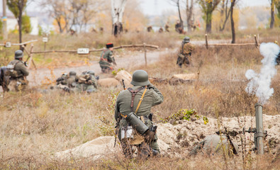 Obraz premium WWII German Soldier shooting with a mortar in trench .
