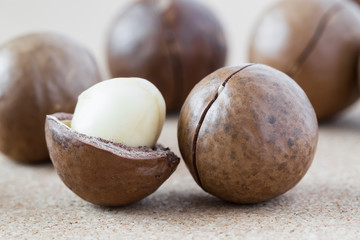 Macadamia nuts on brown background, close-up.