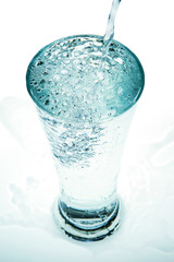 Pour water into a glass on a white background.