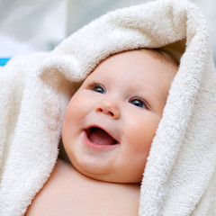 A beautiful smiling baby wrapped in quilt