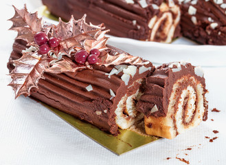 Chocolate roll with the decoration of leaves and berries