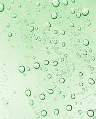 Fototapeta na wymiar water drops on green glass. macro