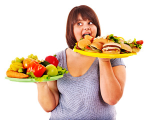 Woman choosing between fruit and hamburger.