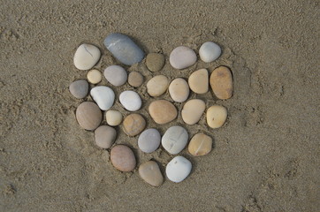 Fototapeta na wymiar Hearth, pebbles composition on the sand