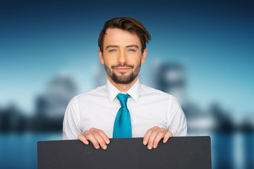 Businessman holding blank poster