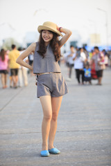 young and pretty asian woman wearing straw hat standing and post