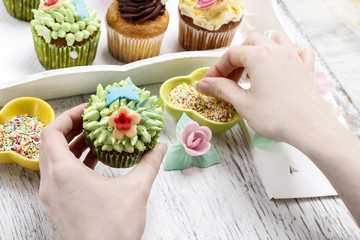 Woman decorates easter cupcakes