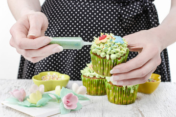 Woman decorates green fairy cupcakes