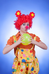 Clown woman with a ball on blue background