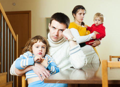 Young couple with children after quarrel at home