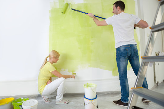 Young Couple Painting Wall