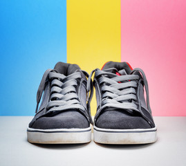 Pair of grey sneakers on colorful background