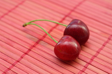 Two fresh cherry on pink background