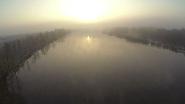 mystical river at sunrise with fog in orange tones.  Aerial