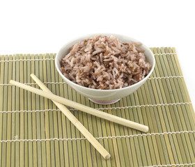 Cooked red rice in bowl and chopstick