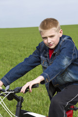 Obraz premium Portrait of the boy sitting by bicycle