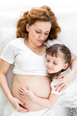 sleeping kid girl hugging pregnant mother