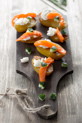 appetizer with salmon,baked potatoes and curd cheese.