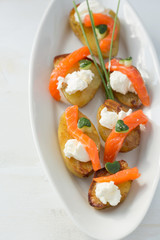 appetizer with salmon,baked potatoes and curd cheese.