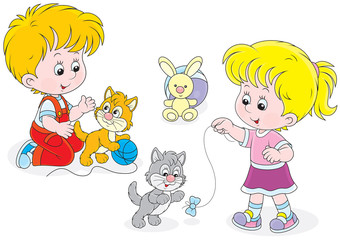 Little girl and boy playing with small playful kittens