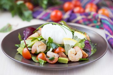 Fresh salad with shrimps, tomatoes, herbs, avocado, poached egg