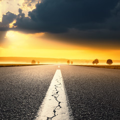 Fototapeta premium Driving on an empty asphalt road at sunrise