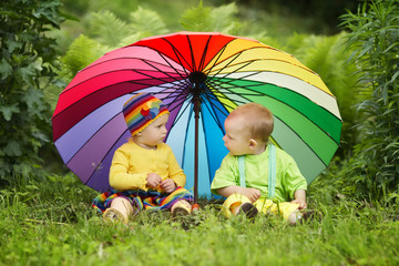 little children under colorful umbrella