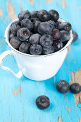 fresh blueberries in a cup on wooden table