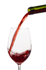 Rotwein wird in ein Weinglas eingegossen