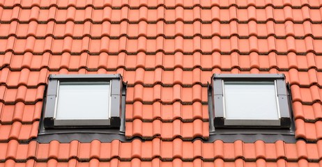 Orange roof with two classic garret windows.